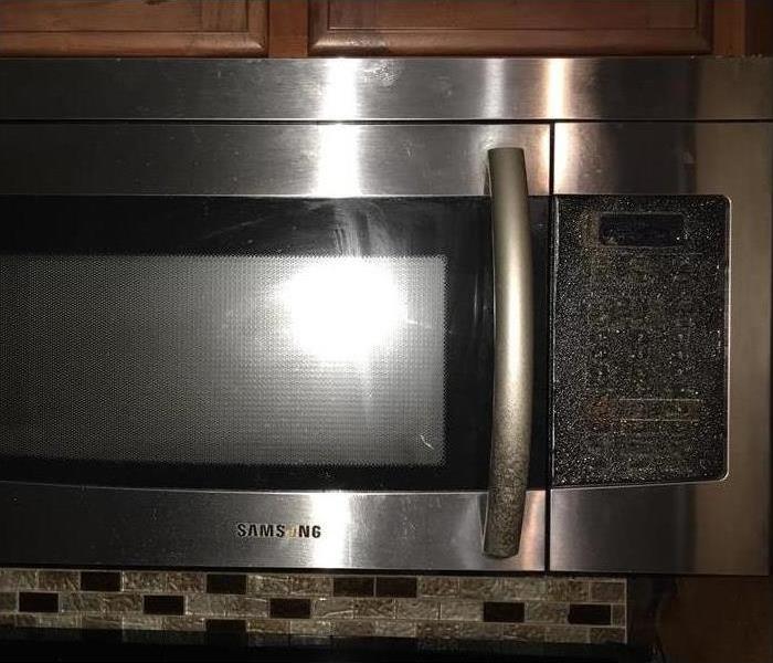 Microwave covered in soot after stove fire