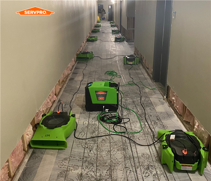 Servpro air movers set up down the hall damaged by water