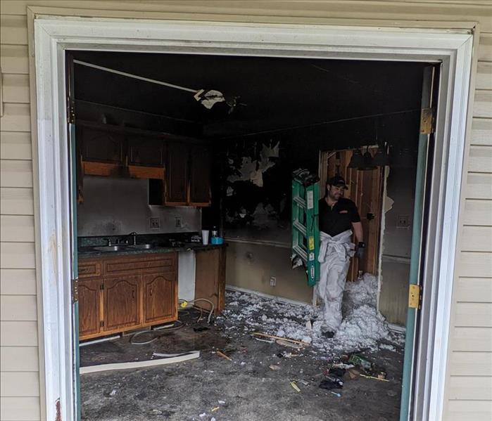 damage from a fire inside a home, looking through the back doors, servpro technician inside